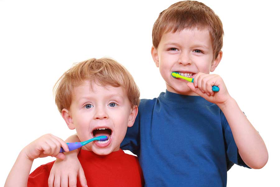 Two young boys brushing their teeth