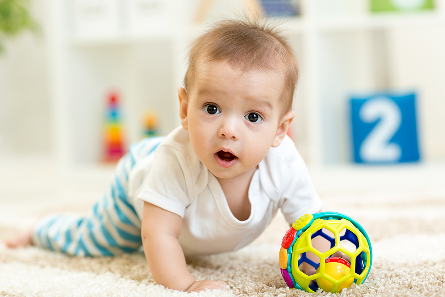 Baby crawling on the floor in nursery room