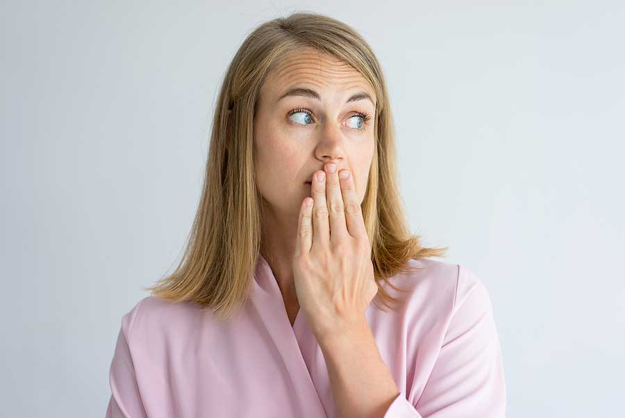 young woman in pink robe covering her mouth