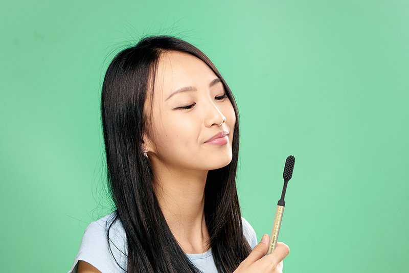 Woman with gold toothbrush